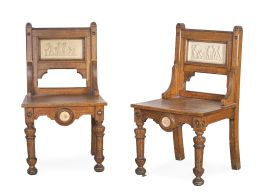 715.  Pareja de "hall chairs" de madera de roble, con placas de escena mitológica y medallones de biscuit con leones.Inglaterra, finales del S. XIX - principios del S. XX.