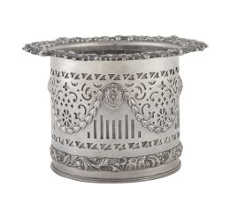 684.  Macetero circular de metal plateado con decoración de guirnaldas y cabezas de león.S. XX.