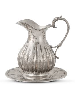 1226.  Jarra gallonado de plata sobre su plato, ley 800. Con marcas.S. XX.