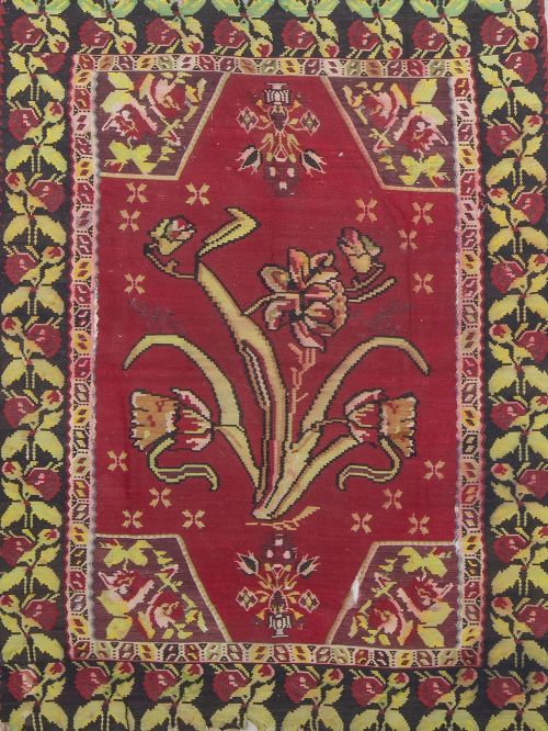 Alfombra turca en lana de campo rojo y cenefa negra con flo