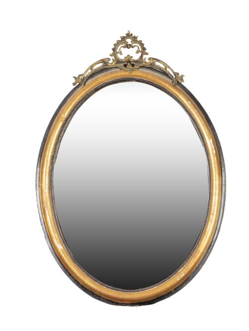 Espejo oval de madera estucada y dorada, con copete de meta