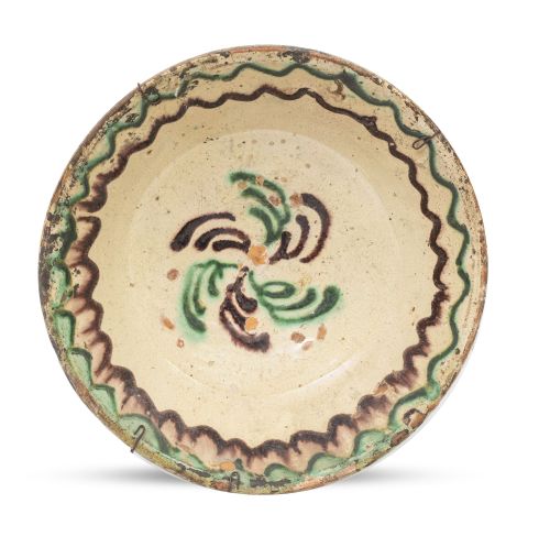 Plato de cerámica esmaltada en verde y manganeso, decorado 