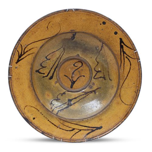 Plato acuencado de cerámica esmaltada en verde y manganeso,