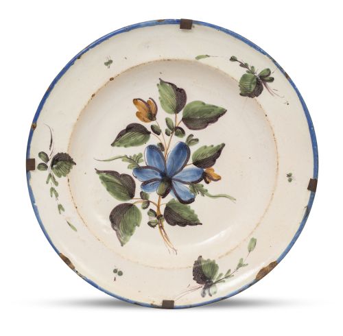 Plato de cerámica esmaltada con ramillete en el asiento en 