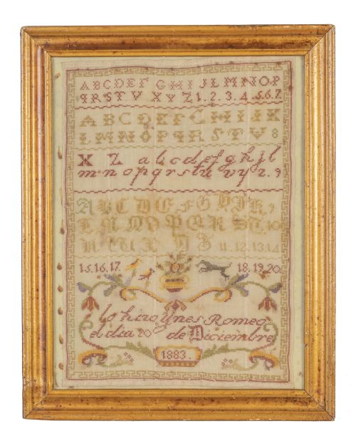 Bordado con abecedario, números y leyenda "Lo hizo Ynes Rom