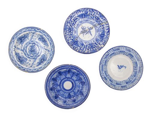 Lote de cuatro platos de cerámica esmaltada en azul y blanc
