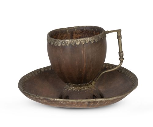 Taza de coco montada en plata, sobre su plato.Trabajo col