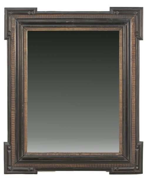 Espejo de madera ebonizada con moldurada rizada y dorada.