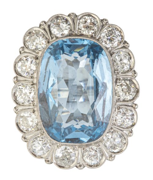 Sortija c. 1920 con piedra azul central enmarcada en montur