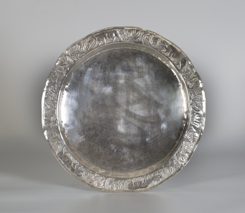 Plato de plata con decoración repujada y grabada, en el ale