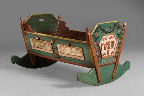 Cuna de madera tallada y policromada, con decoración de flo