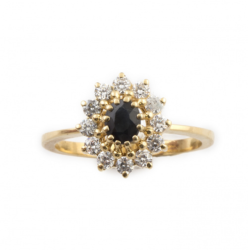 Sortija con zafiro de talla oval orlado de circonitas, en o