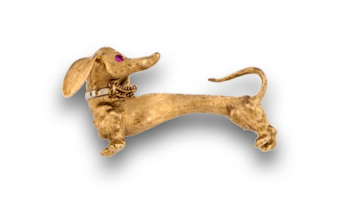 Broche teckel en oro mate de 18K con ojo de rubí.