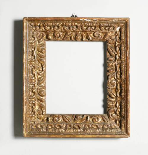 Marco en madera tallada, estucada y dorada. Decorado con gu