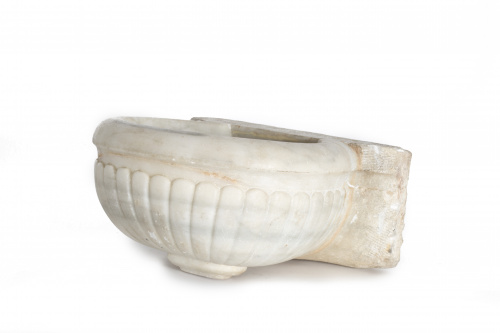 Pila de agua bendita de mármol con decoración de gallones.