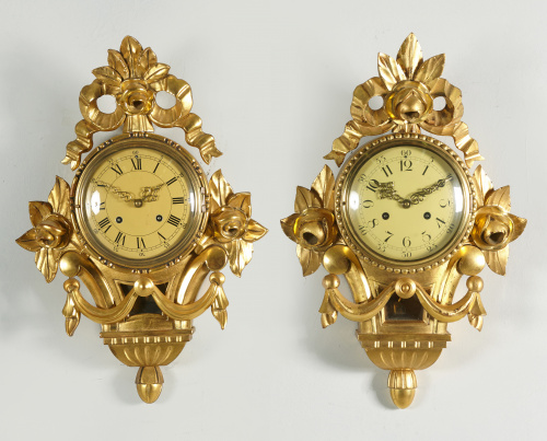 Pareja de relojes de estilo Luis XVI de madera tallada y do
