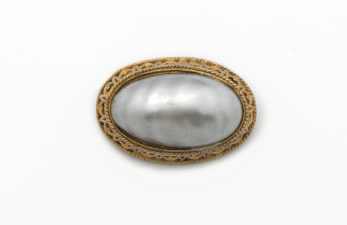 Broche de gran perla mabe gris con marco en metal dorado.