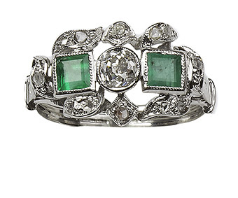 Sortija de esmeraldas y brillantes en torno a un brillante 