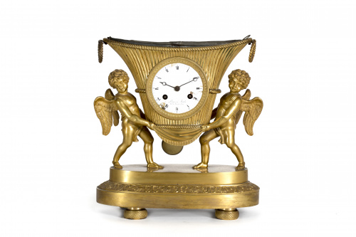Reloj de sobremesa Imperio en bronce dorado, en el que dos 