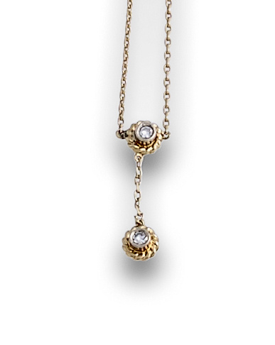 Cadena fina con dos brillantes en marco de cordoncillo.