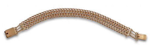 Pulsera con tres cadenas de eslabón barbado en oro de 18K.