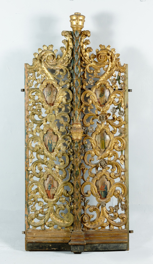 Puerta de madera tallada y dorada, con santos en cartelas.