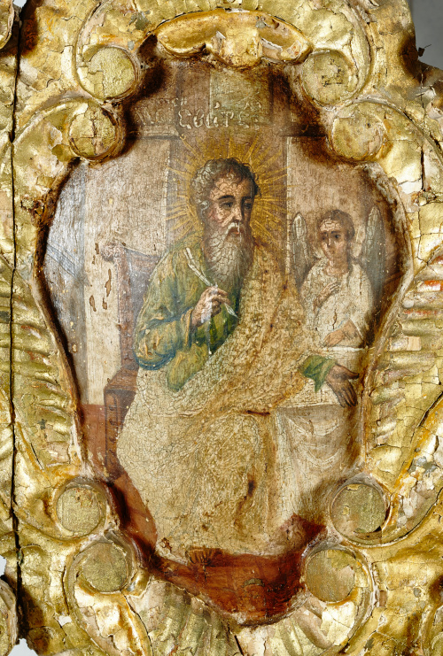 Puerta de madera tallada y dorada, con santos en cartelas.