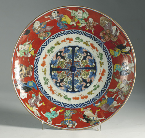 Plato de porcelana esmaltada en rojo y personajes en el ale