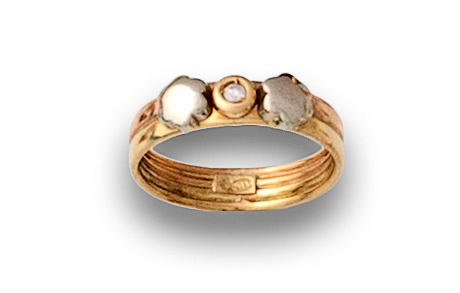 Sortija con brillantito entre flores de oro bicolor de 18K.