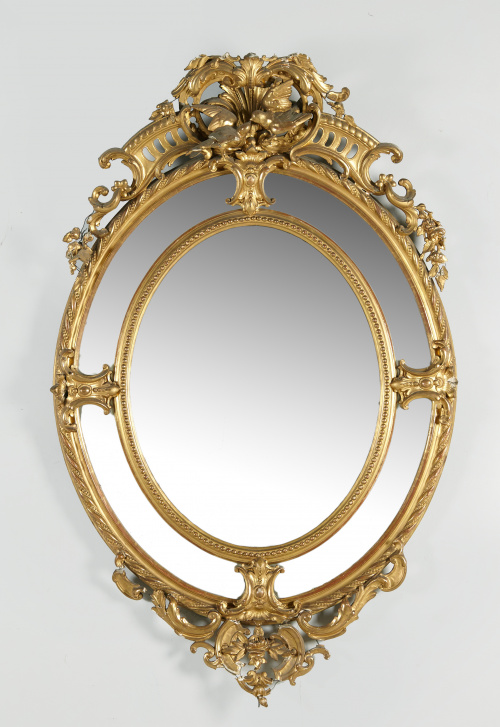 Espejo oval de madera tallada,estucada y dorada. Trabajo e