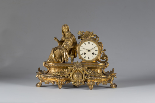 Reloj de sobremesa de bronce dorado con una dama sobre el p