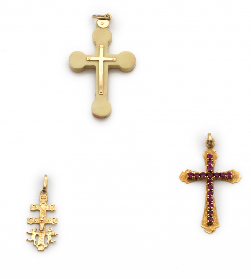 Lote de dos cruces colgantes en oro de 18K.