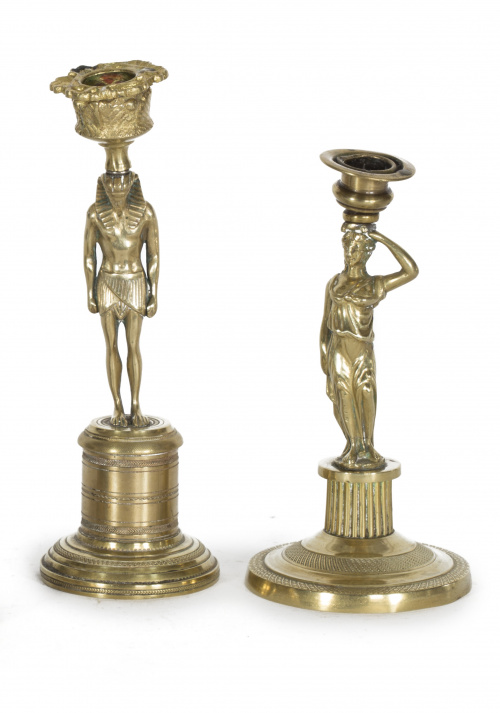 Dos candeleros de bronce dorado, uno con la figura de un eg