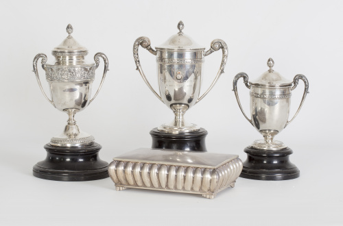 Tres trofeos de plata, uno con la leyenda  “Sociedad de Tir