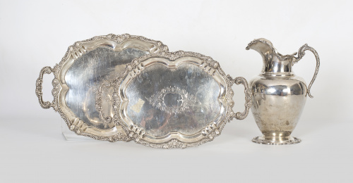 Dos bandejas ovales de plata con contorno de flores y cinta