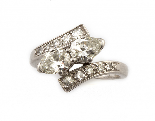 Sortija con dos diamantes talla perilla entre brazos abiert