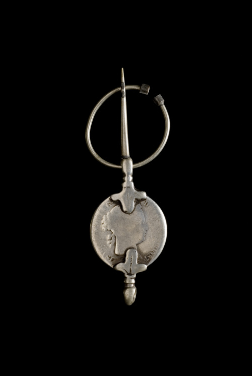 Lote formado por doce fíbulas con monedas 