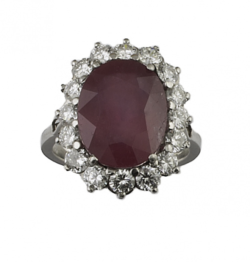 Sortija con rubí oval de 7 ct. aprox. orlado de brillantes,
