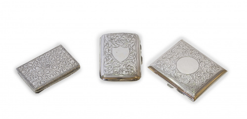 Lote de dos pitilleras de plata y un cerillero con decoraci
