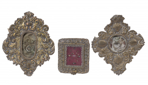 Tres relicarios con marcos de metal repujados y dorados.T