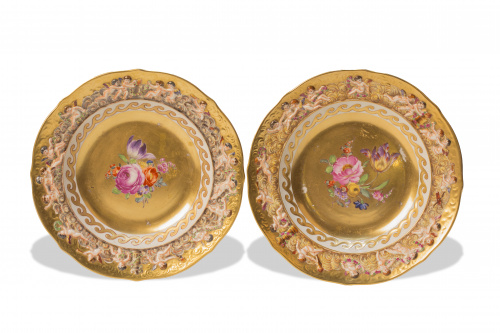 Dos platos de porcelana esmaltada y dorada, con flores pint