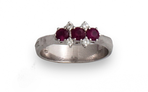 Sortija tresillo de rubíes entre brillantes.