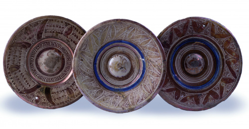 Tres platos esmaltados de reflejo metálico y azul cobalto.