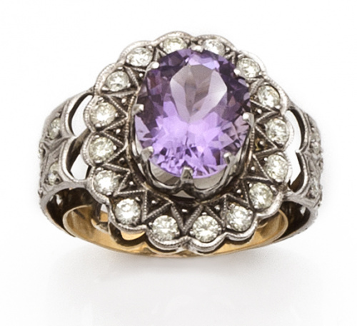 Sortija con amatista oval orlada de brillantes y con dos ba
