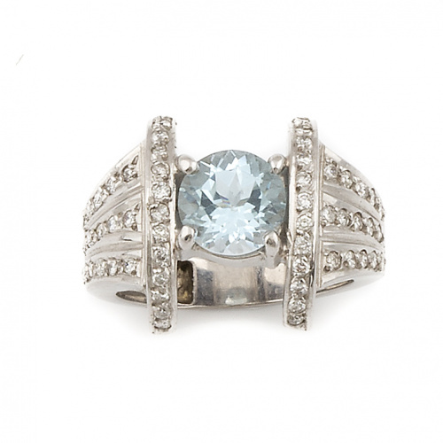 Sortija con topacio azul de talla redonda entre brazos a mo