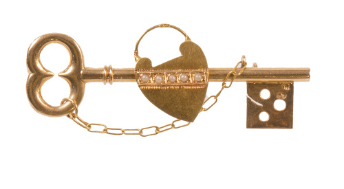 Broche S. XIX en forma de llave con candado central de cora