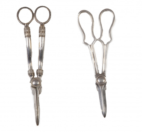 Dos pinzas para uvas en plateado.Una con marcas de Mappin