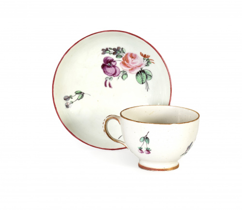 Taza y plato de “porcelana” esmaltada con flores alemanas.