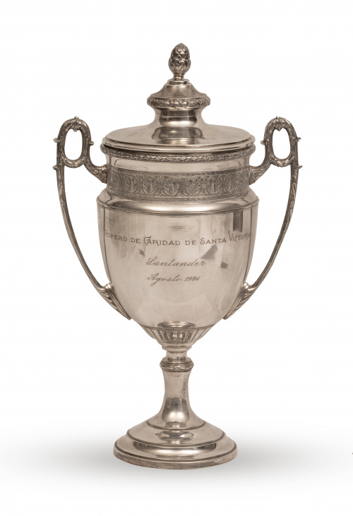 Trofeo de metal plateado con leyenda "Ropero de Caridad de 