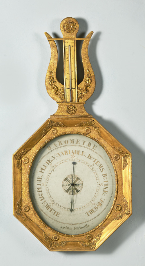 Barómetro rematado en lira de madera estucada y dorada.Tra